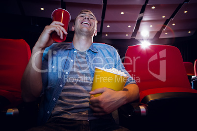 Happy young man watching a film