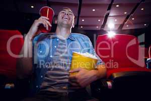 Happy young man watching a film