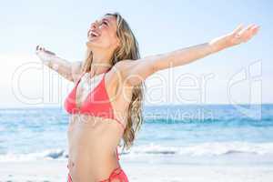 Smiling blonde in bikini arms outstretched