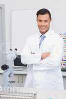 Happy scientist smiling at camera with arms crossed