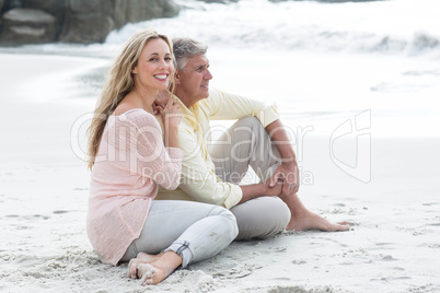 Happy couple sitting on the sand