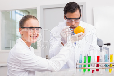 Scientists injecting orange