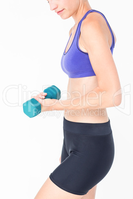 Pretty woman in sportswear lifting dumbbell