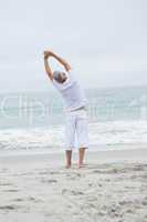 Man stretching his arms by the sea