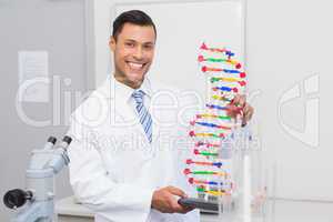 Happy scientist smiling at camera with DNA helix