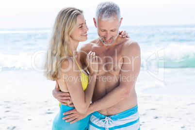 Happy couple standing by the sea and hugging each other