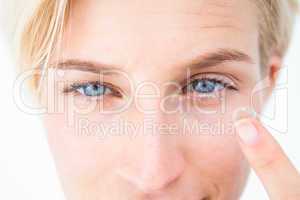 Pretty blonde applying contact lens