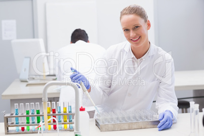 Happy scientist examining tubes