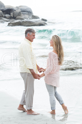 Happy couple holding hands and smiling at each other