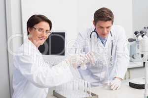 Scientists pouring chemical fluid in funnel