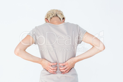 Blonde woman having a back ache and holding her back