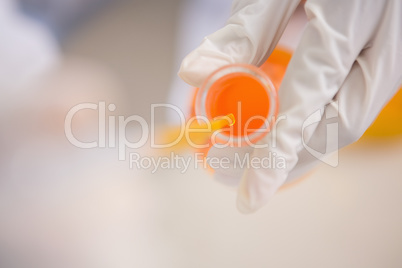 Scientist examining orange fluid