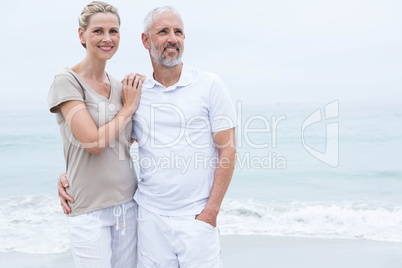 Happy couple hugging each other by the sea