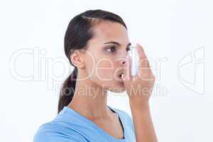 Pretty woman using her inhaler