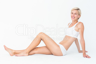 Pretty woman sitting on the floor smiling at the camera