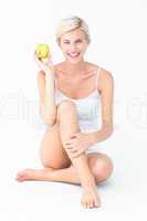 Sitting woman holding an apple