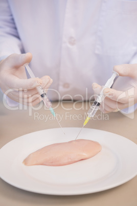 Scientist injecting piece of meat