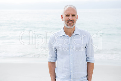 Smiling man standing by the sea hands in pocket Smiling man standing by the sea hands in pocket