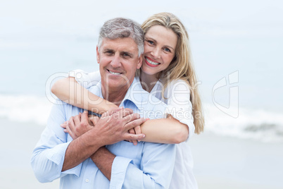 Happy couple hugging each other and looking at camera