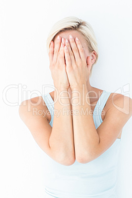 Sad blonde woman with head on hands