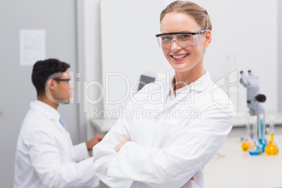 Smiling scientist looking at camera arms crossed