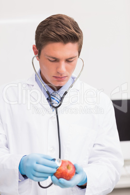 Scientist listening apple with stethoscope