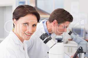 Scientists looking attentively in microscopes