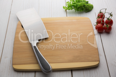 Chopping board with large knife and ingredients