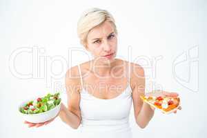 Pretty woman deciding between pizza and salad