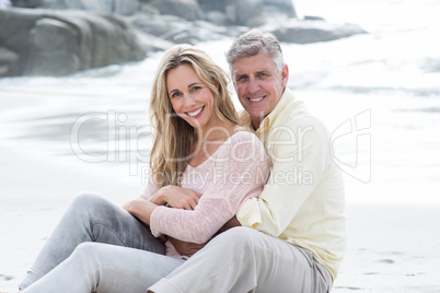 Happy couple sitting on the sand