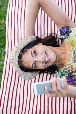 Smiling beautiful brunette lying on the blanket