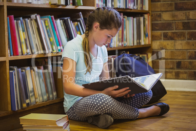 Little girl reading on library floor