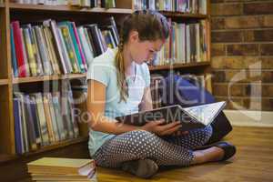 Little girl reading on library floor