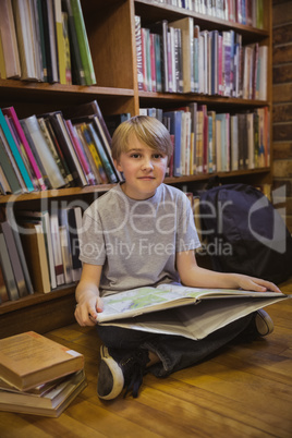 Little boy reading on library floor