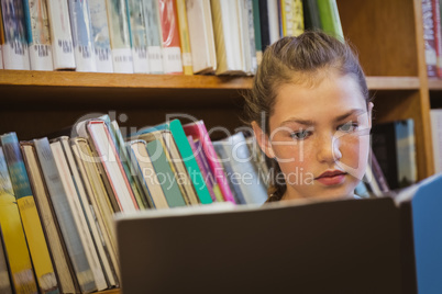 Little girl reading on library floor