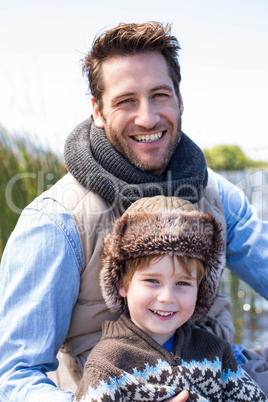 Happy casual father and son at a lake