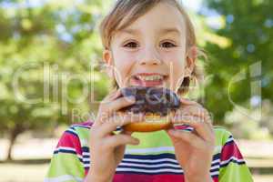 Little boy eating chocolate doughnut