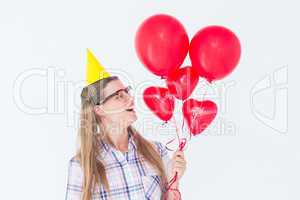 Geeky hipster holding red balloons