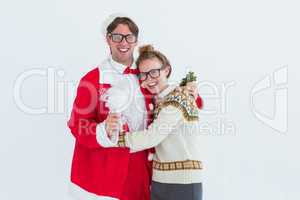 Geeky hipster in santa costume hugging his girlfriend