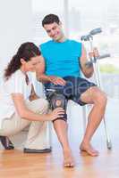 Doctor examining her patient knee