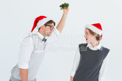 Geeky hipster holding mistletoe