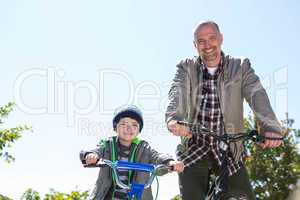 Happy father on a bike with his son