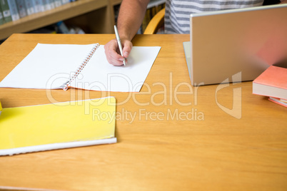 Student studying in the library with laptop