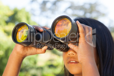 Cute little girl looking through binoculars