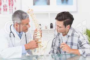 Doctor explaining anatomical spine to his patient