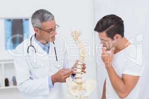 Doctor explaining anatomical spine to his patient