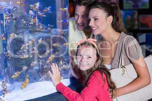 Happy family looking at fish tank