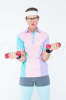 Geeky hipster girl lifting dumbbells