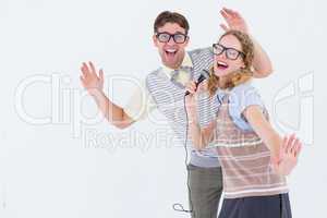 Geeky hipster couple singing into a microphone