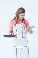 Happy hipster woman holding laptop and frying pan